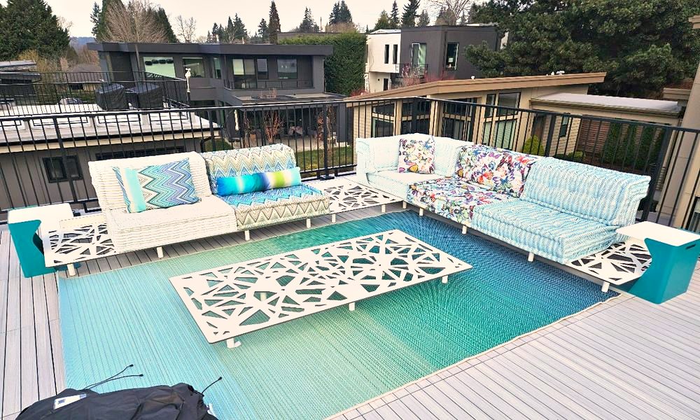 Outdoor furniture installed on a waterfront deck beside a pool