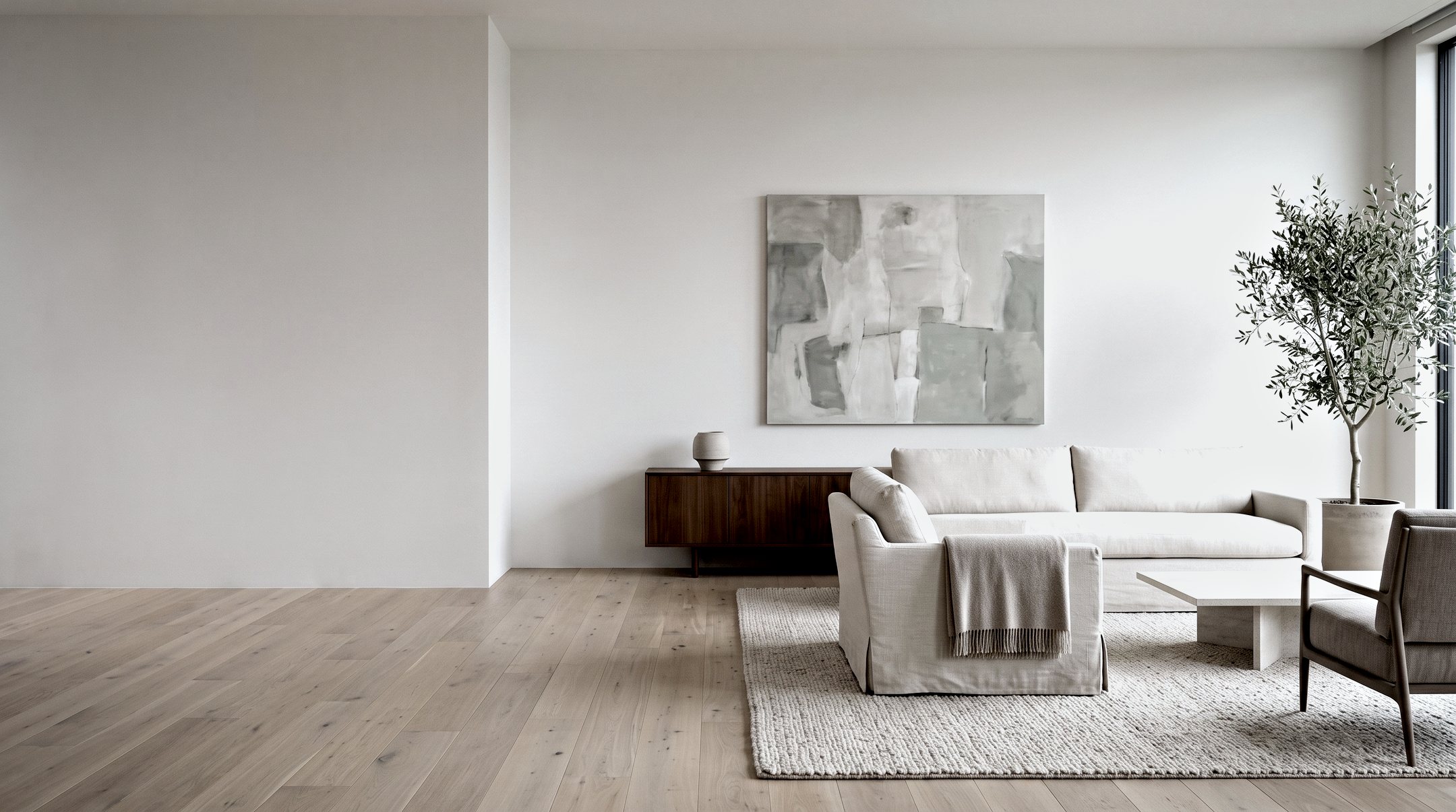 A calm living room with the furniture newly placed — sofa, walnut console and a single canvas